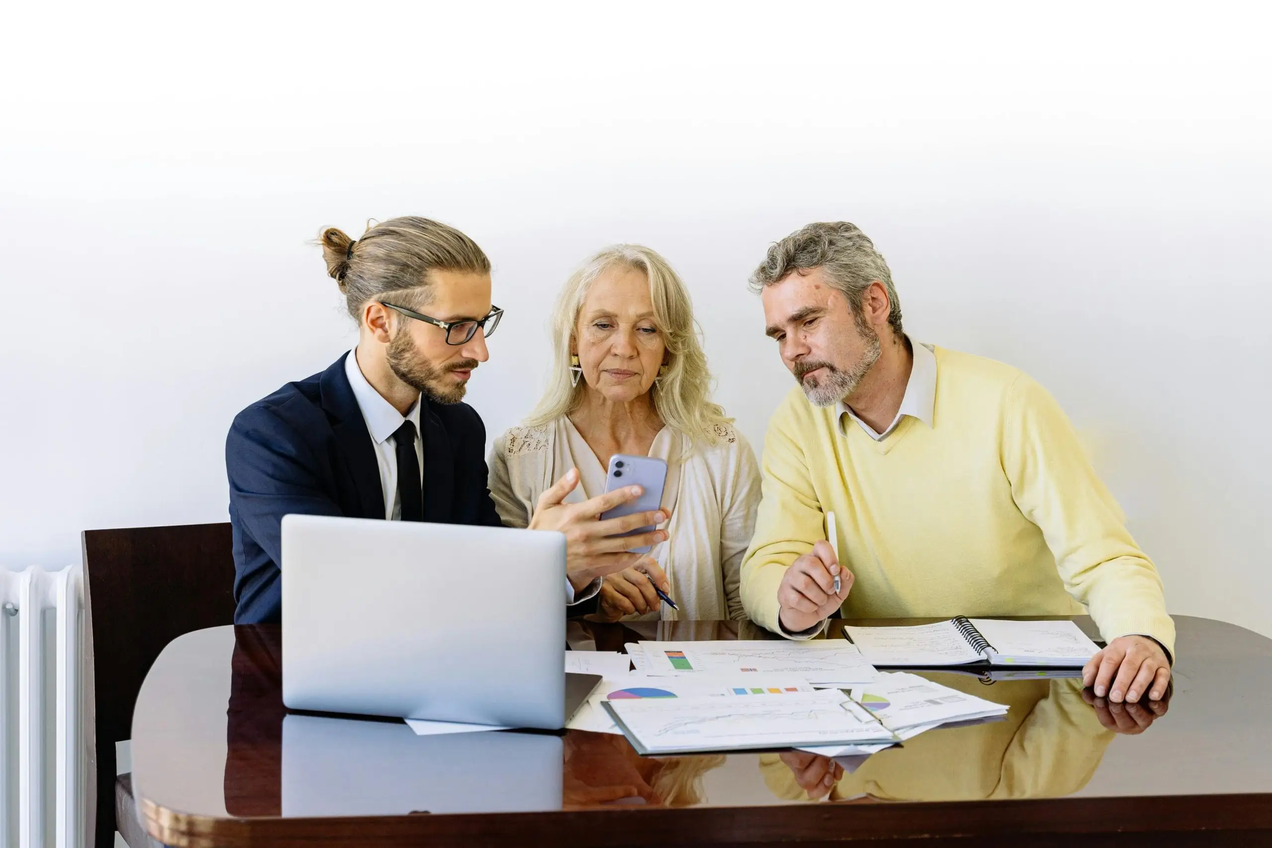Financial advisor reviews documents with foreign investor couple.