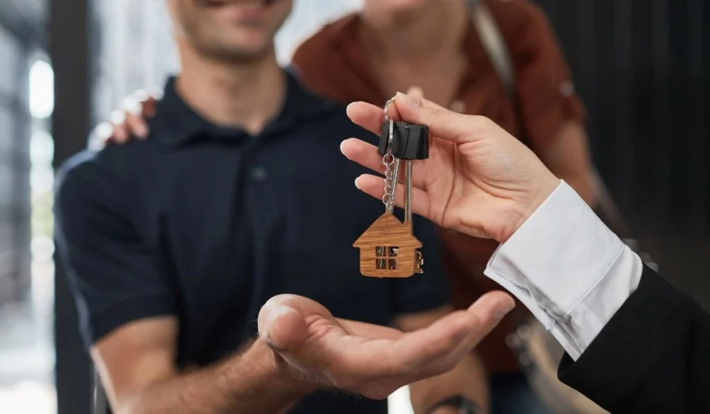 Real estate agent handing house keys to a couple in Florida.