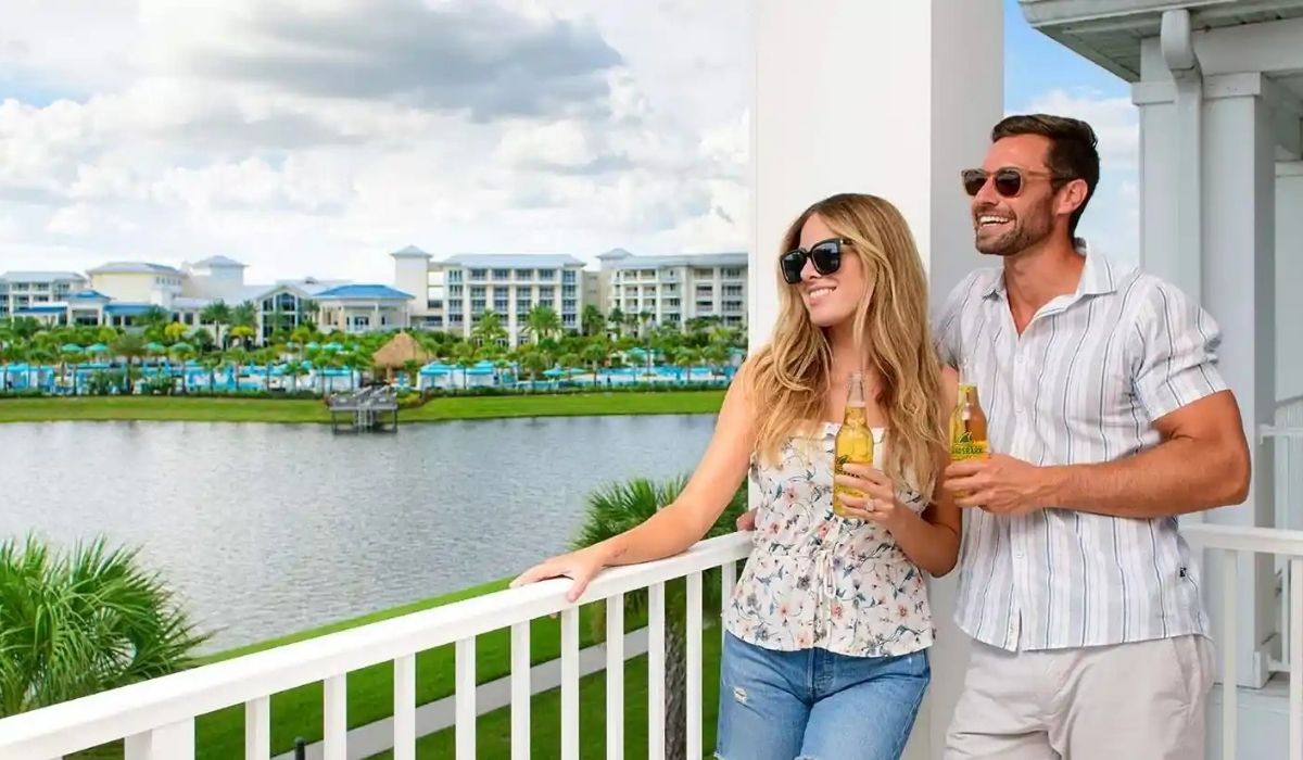 Una pareja en un balcón con vista al agua, disfrutando de un momento juntos.