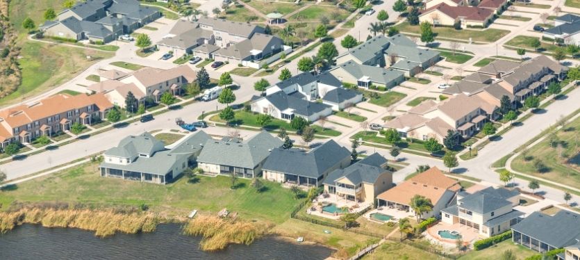 Overhead perspective of a residential area with houses and a tranquil lake, highlighting the layout and natural surroundings