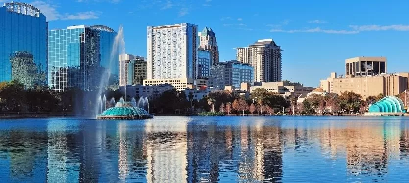 Orlando, Florida, vista de la ciudad con rascacielos y palmeras bajo un cielo despejado.