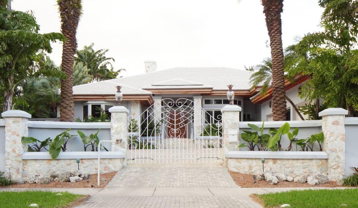 Casa en miami con una entrada cerrada y palmeras, rodeada de un ambiente tropical y acogedor