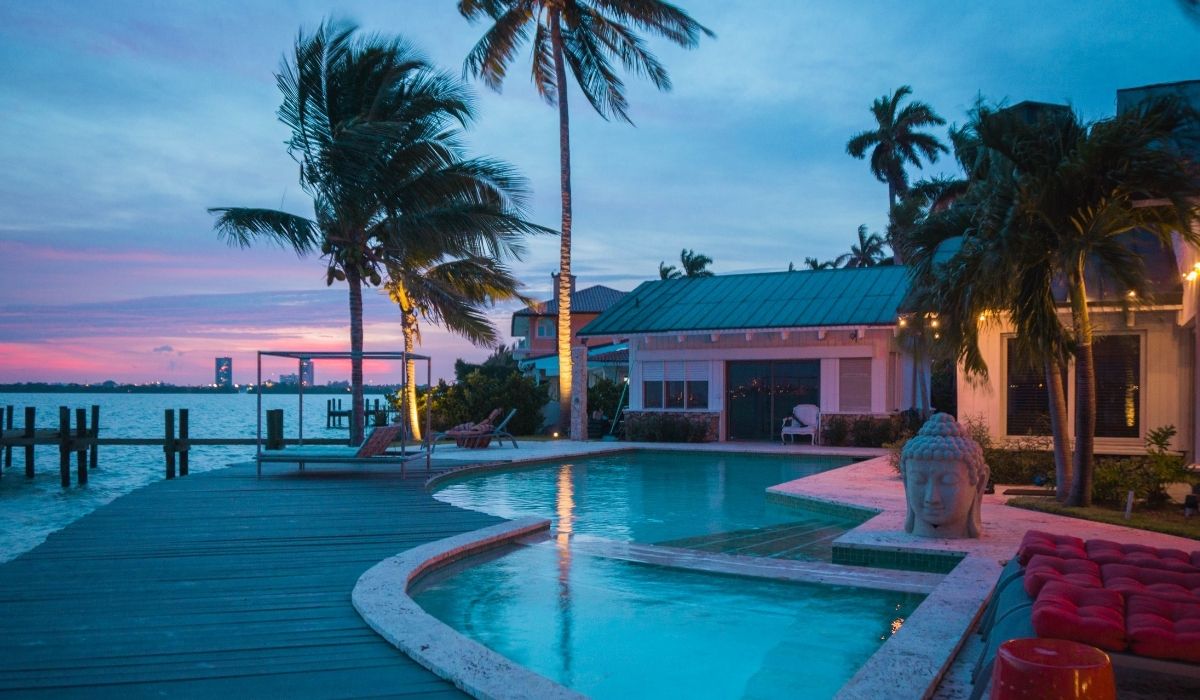 proyectos exclusivos de vista del atardecer sobre la piscina y el muelle, con colores cálidos reflejándose en el agua tranquila