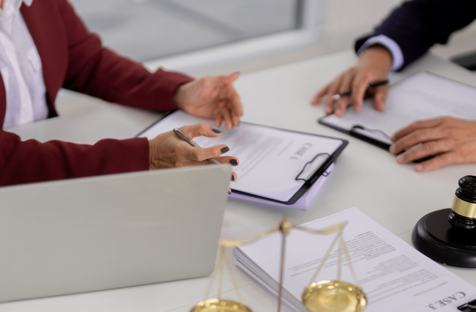 Dos personas de negocios sentadas a una mesa con un portátil y documentos, discutiendo sobre la apertura de una LLC en Florida