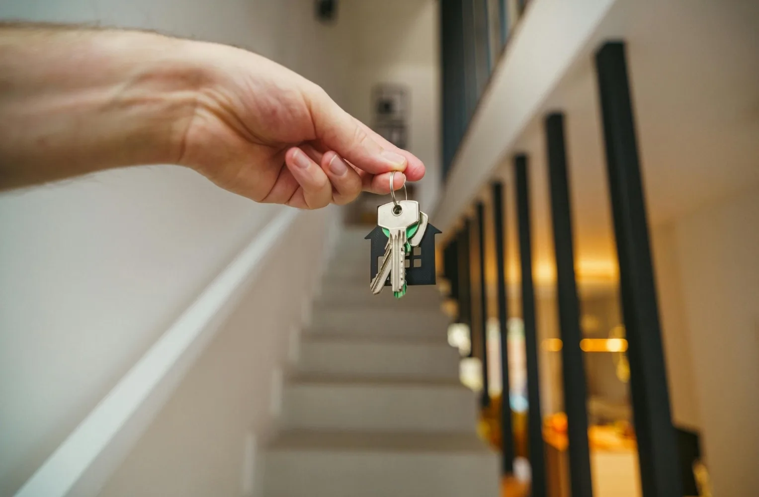 A person holding a house key, symbolizing the purchase of a home in Florida for living or investment.