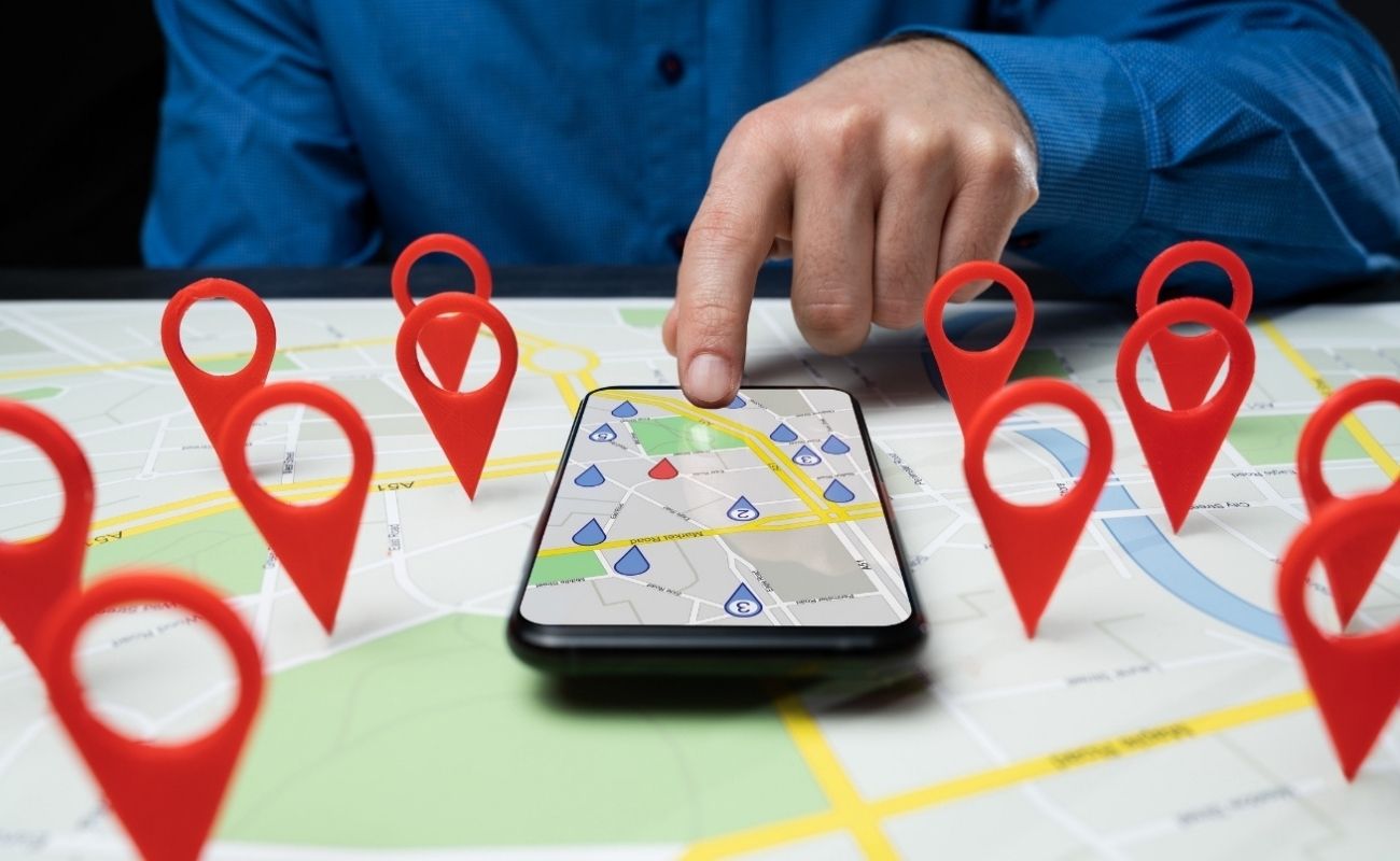 Man using a smartphone to search for a location on a map, exploring real estate opportunities in Central Florida