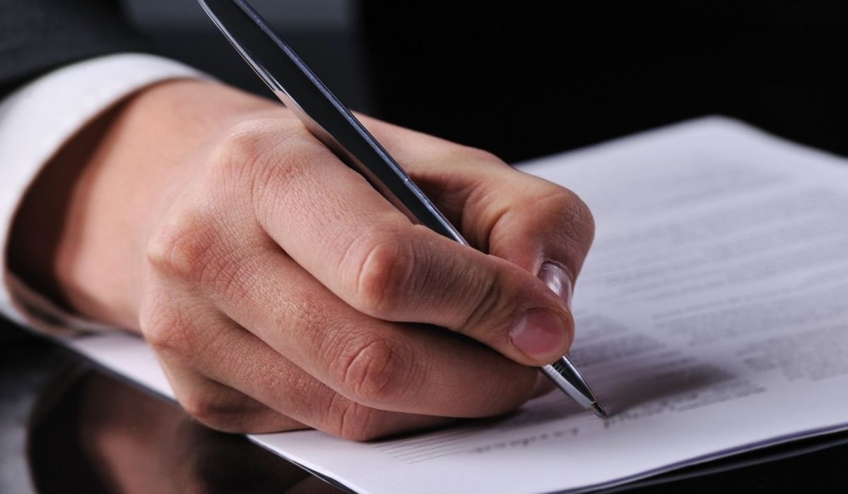 Persona en traje escribiendo en papel sobre estrategias para reducir riesgos al invertir en Florida