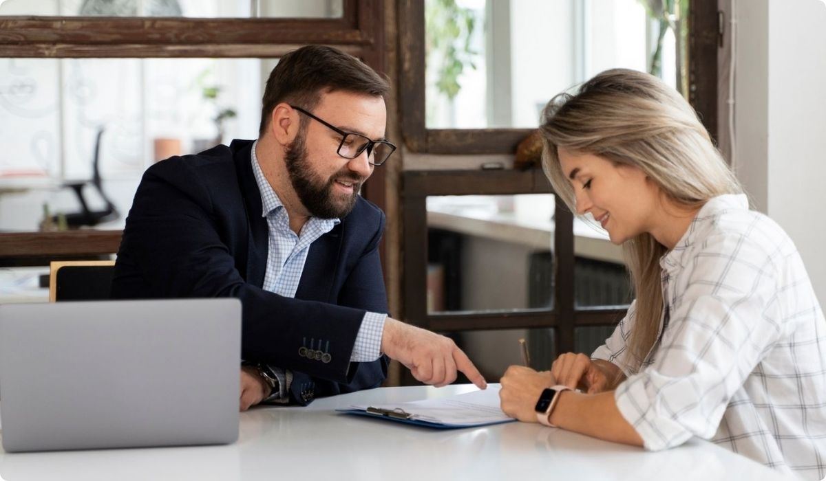 A man and a woman sitting at a table with a laptop, discussing investment strategies in Florida.