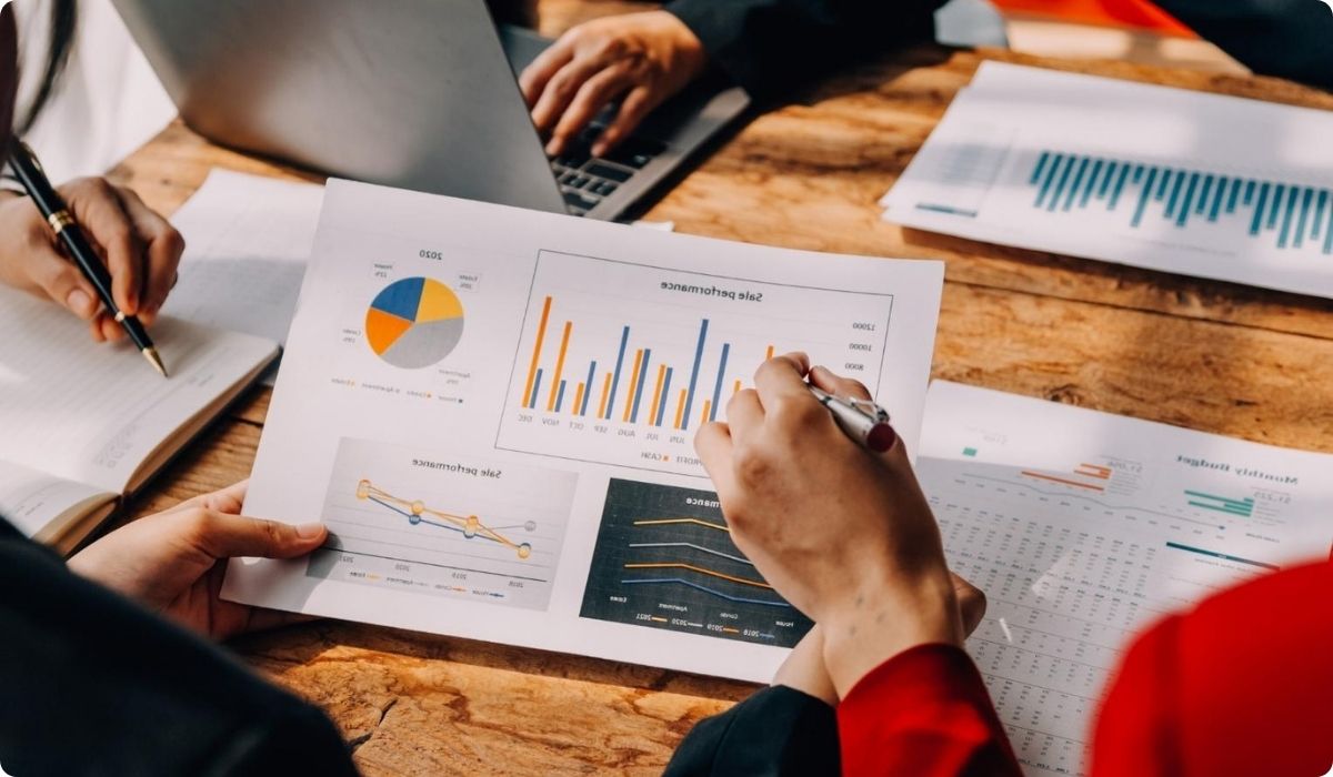Personas de negocios revisando un documento con gráficos sobre gastos adicionales en inversiones inmobiliarias en Florida.