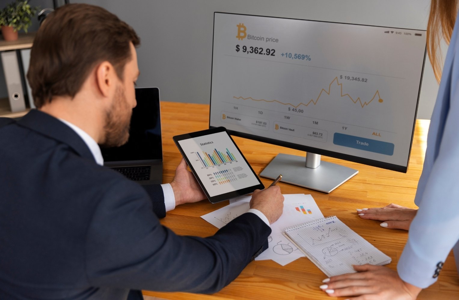 Un hombre y una mujer observan un gráfico en la pantalla de una computadora sobre inversiones en Miami con bajo presupuesto.