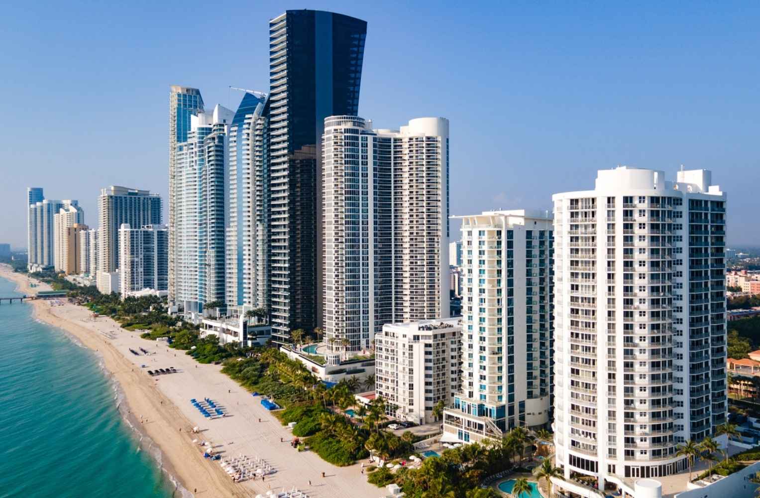 Playa y edificios altos en Miami, ideal para invertir en proyectos frente al mar.