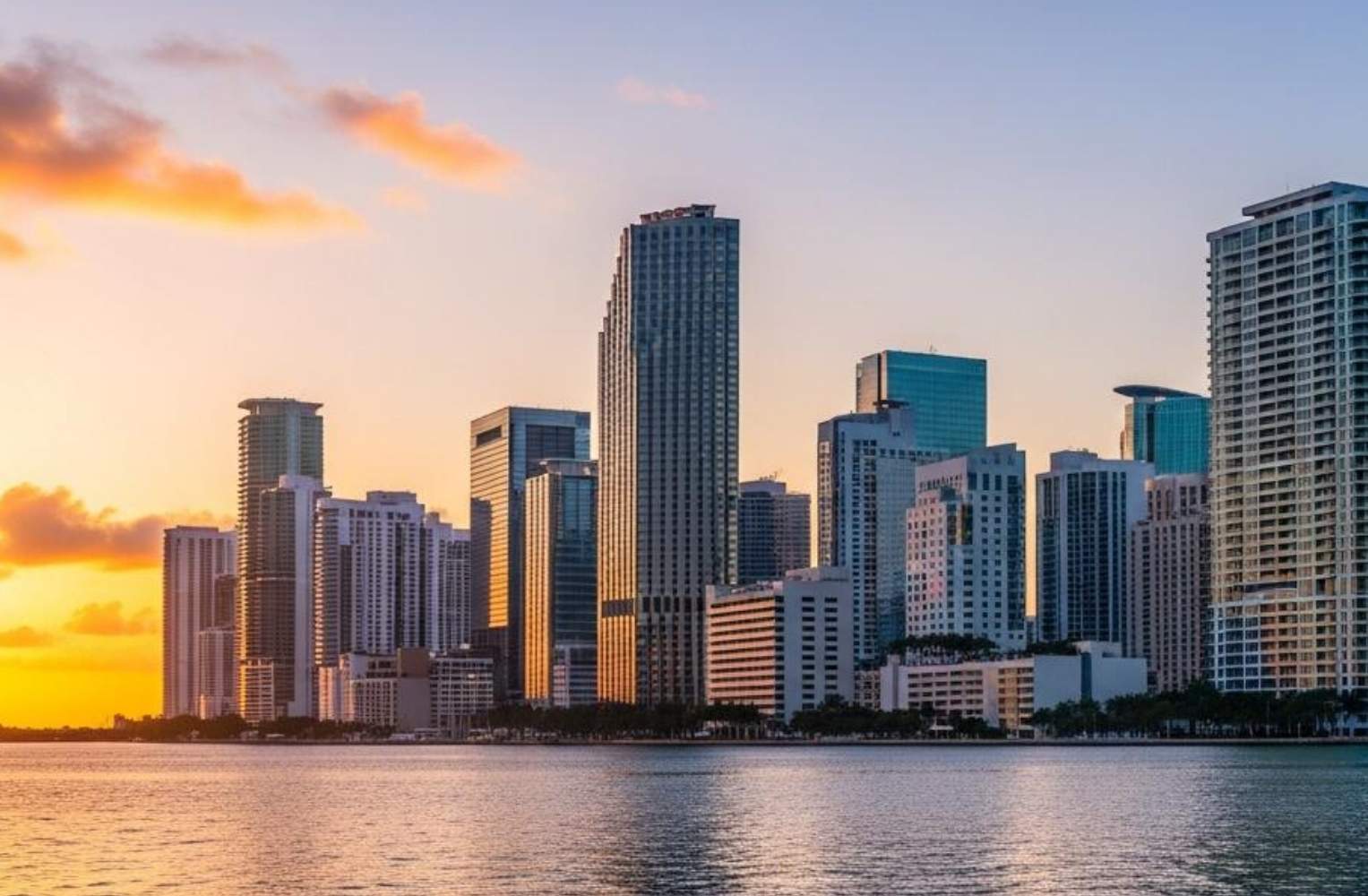 Skyline de Miami al atardecer, con colores cálidos y edificios destacados, reflejando la vibrante vida de la ciudad.