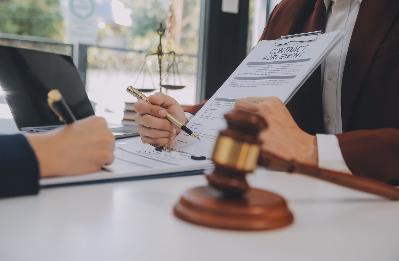 Abogado y cliente firmando documentos en una oficina, discutiendo permisos para comprar casa en Florida.