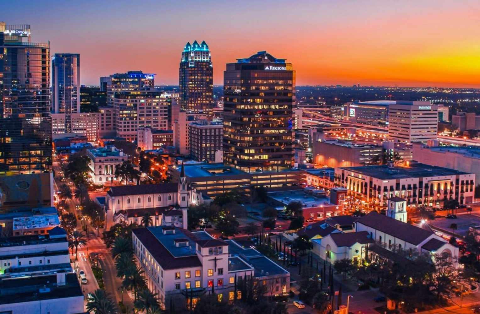 atardecer, con colores cálidos iluminando los edificios en el centro de la ciudad.