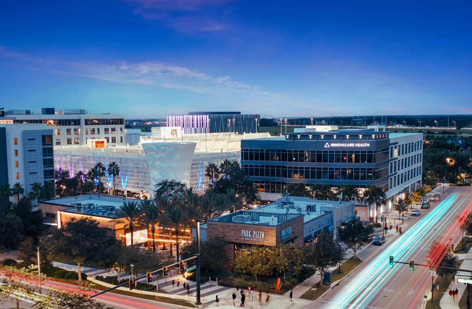 Florida al atardecer, con luces de la ciudad brillando y un cielo en tonos anaranjados y morados.