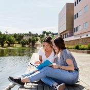 Dos jóvenes estudiantes sentadas en un muelle junto a un lago en Orlando