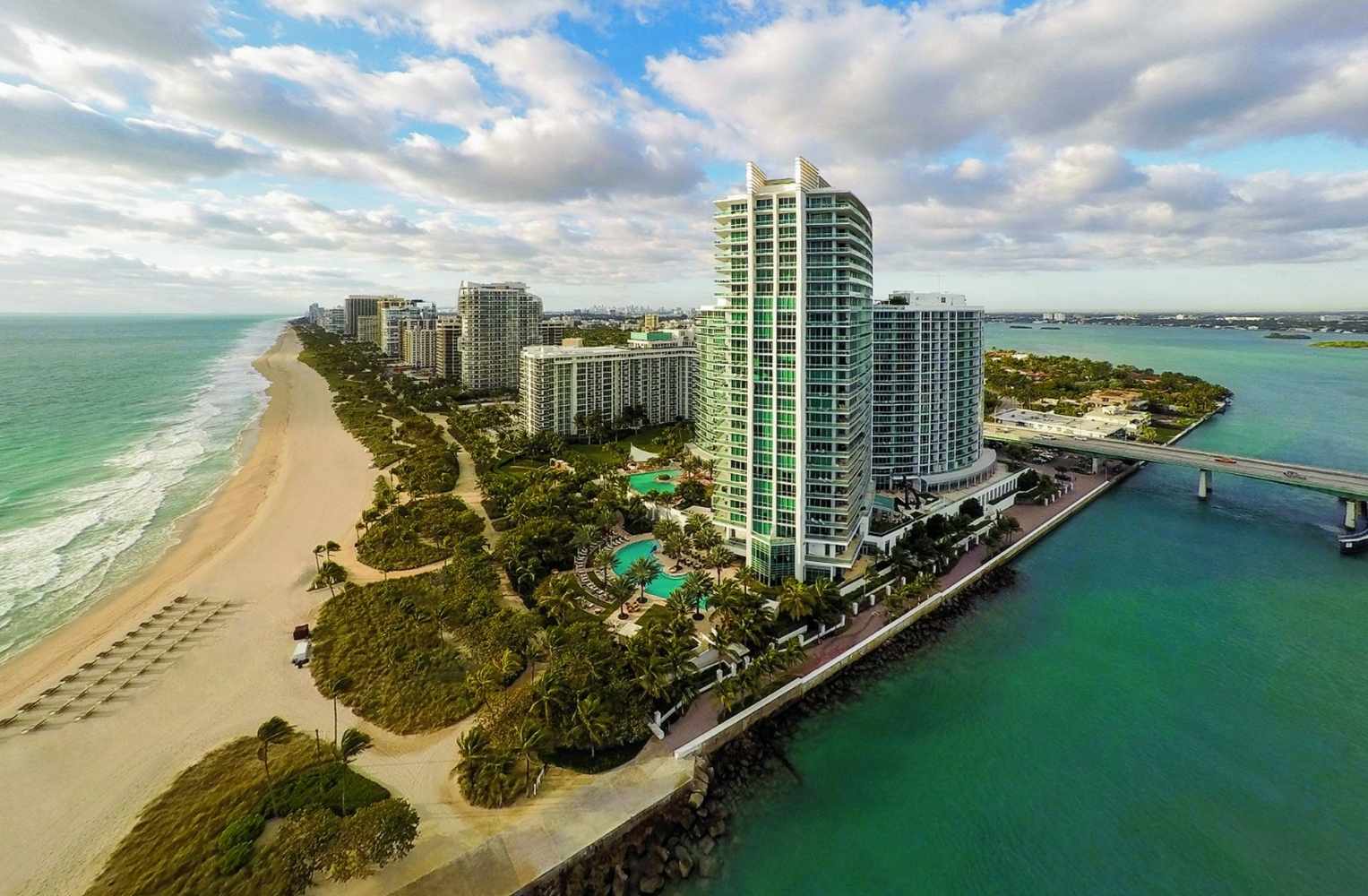 Vista aérea de la playa en Miami, mostrando la costa y el agua azul brillante.