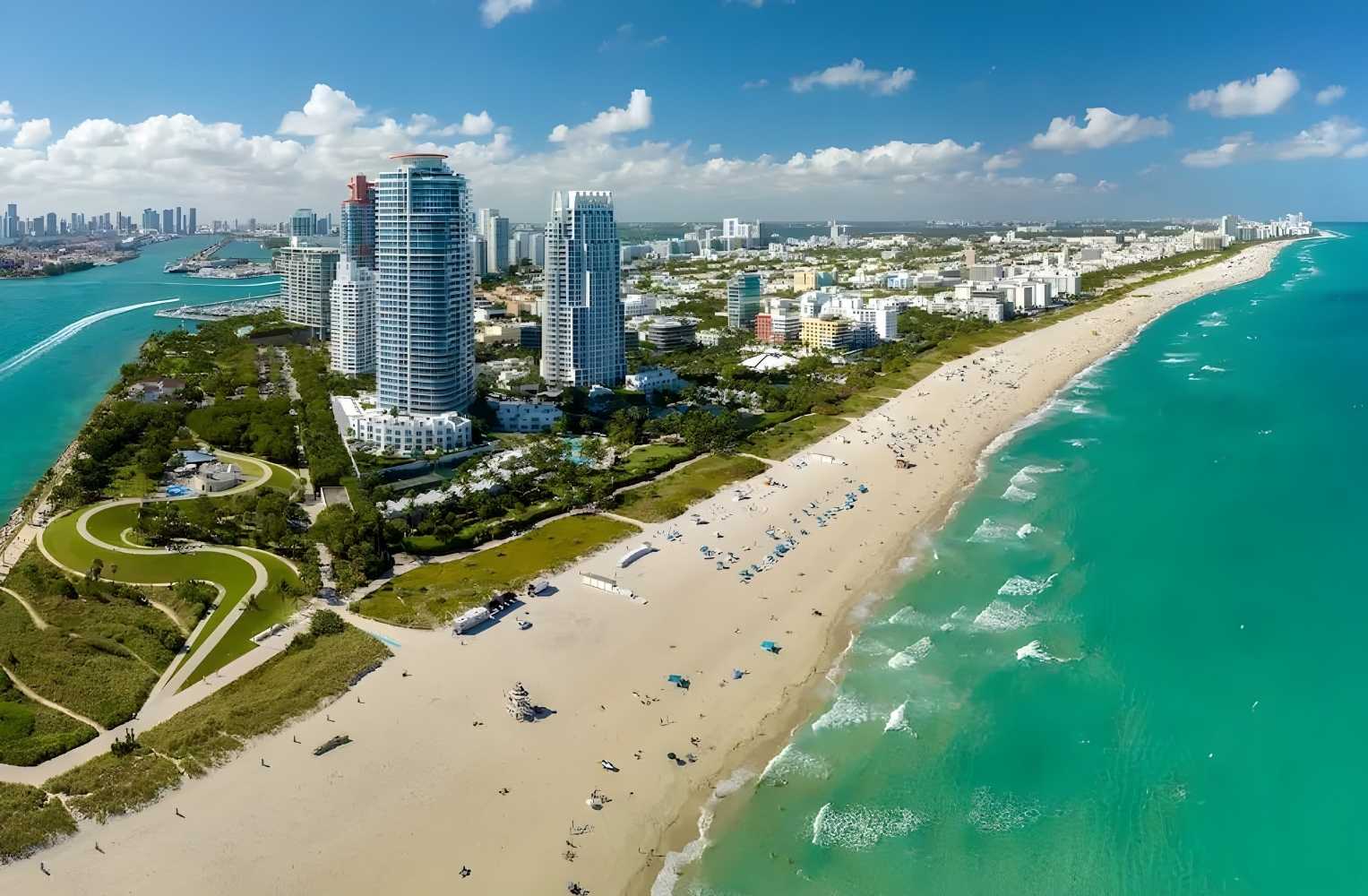 Vista aérea de Miami Beach, mostrando playas, edificios y el océano en un día soleado.
