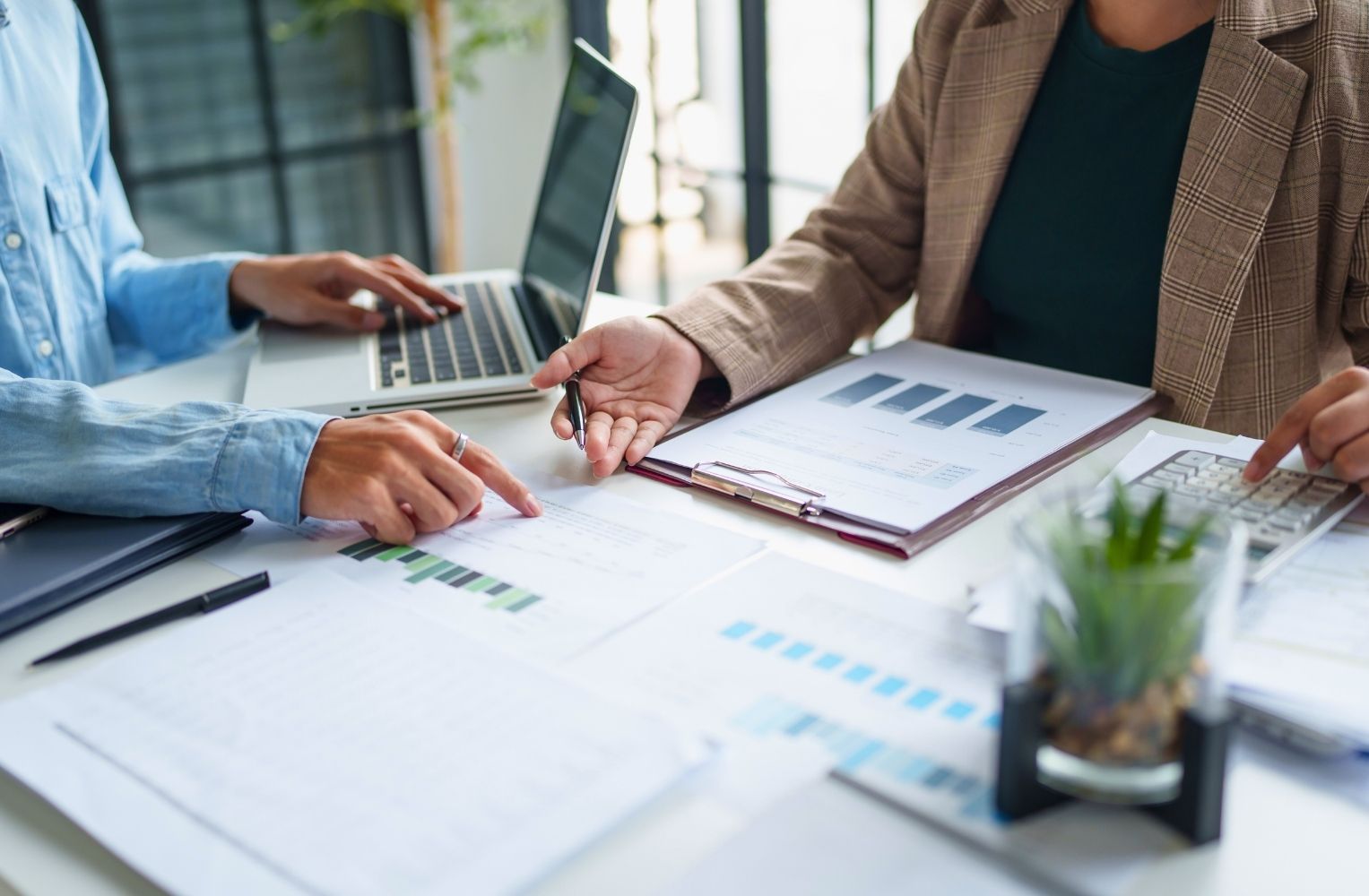 Personas de negocios revisando documentos en un escritorio, colaborando en tareas administrativas.