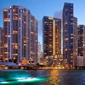Un barco atracado frente a altos edificios iluminados por la noche.