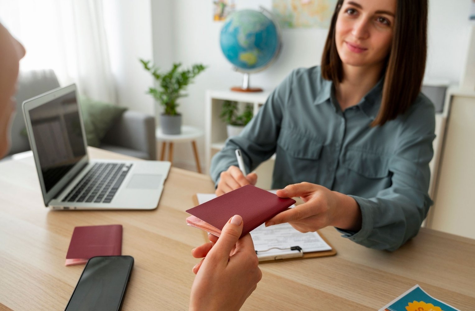 A woman hands a passport to another woman in a friendly atmosphere.