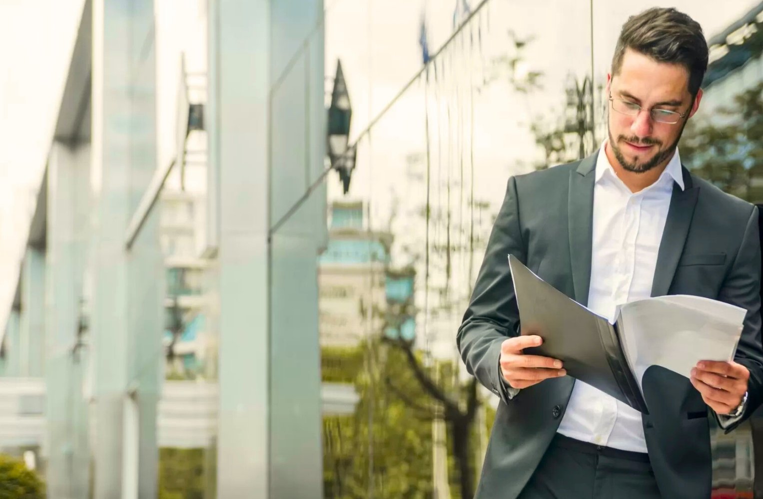 Un hombre en traje revisa un documento con interés.