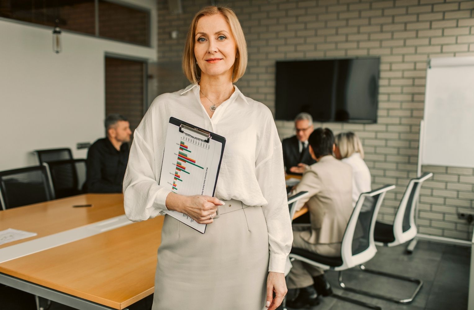 Woman in a business suit, holding a folder.
