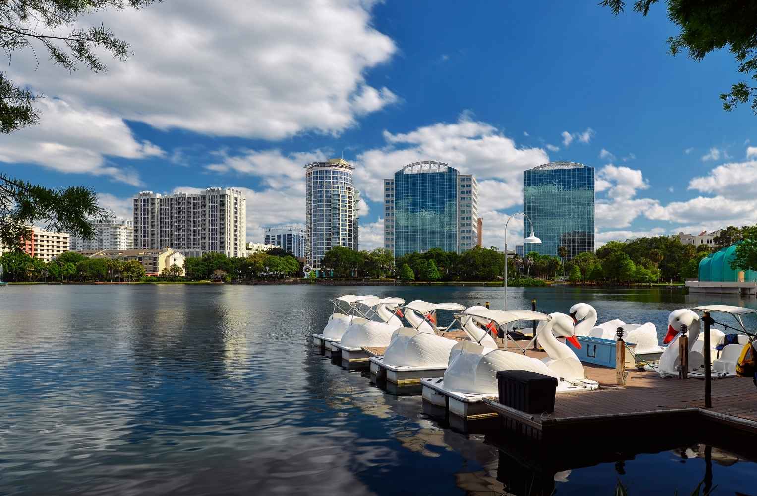 Vista del lago Eola en el centro de Orlando con sus icónicos botes de pedal en forma de cisne y edificios corporativos de fondo