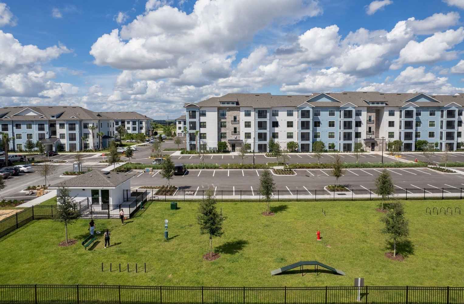 Complejo residencial de apartamentos modernos en Orlando, Florida, con amplias zonas verdes, parque para perros y estacionamiento.