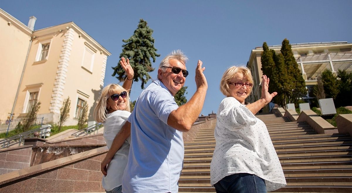 Adultos mayores activos saludando en una propiedad de retiro en Florida, destacando la calidad de vida y el entorno social para inversores.