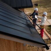 Trabajadores instalan techo en propiedad en renovación, representando proyectos fix and flip y oportunidades de inversión inmobiliaria.