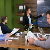 Presentación de Real Estate Syndication en Orlando para inversores extranjeros, mostrando análisis de datos, reportes de rentabilidad y proyecciones de inversión inmobiliaria colectiva en una oficina moderna.