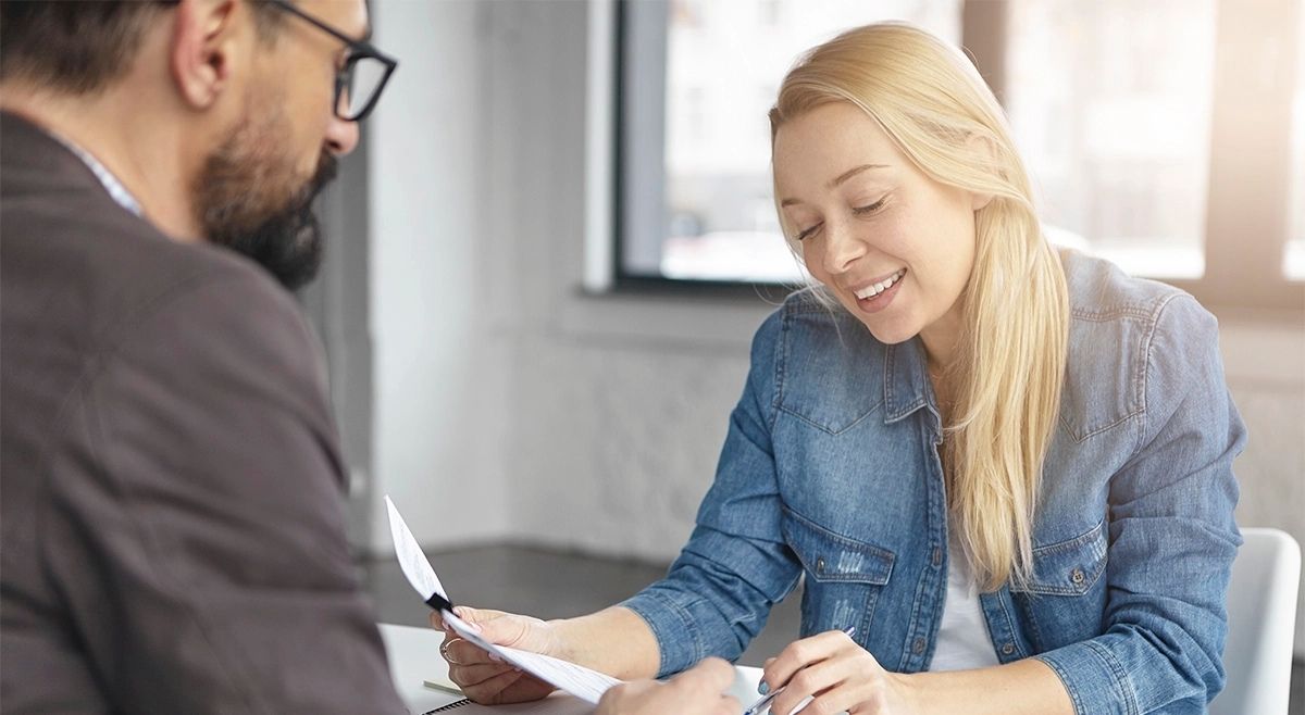 Cliente revisa documentos con asesor financiero durante proceso de refinanciamiento hipotecario en Florida para inversionistas extranjeros.