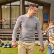 Familia joven frente a una casa unifamiliar en Orlando, representando la estabilidad del programa Section 8 y la renta garantizada para inversores extranjeros.