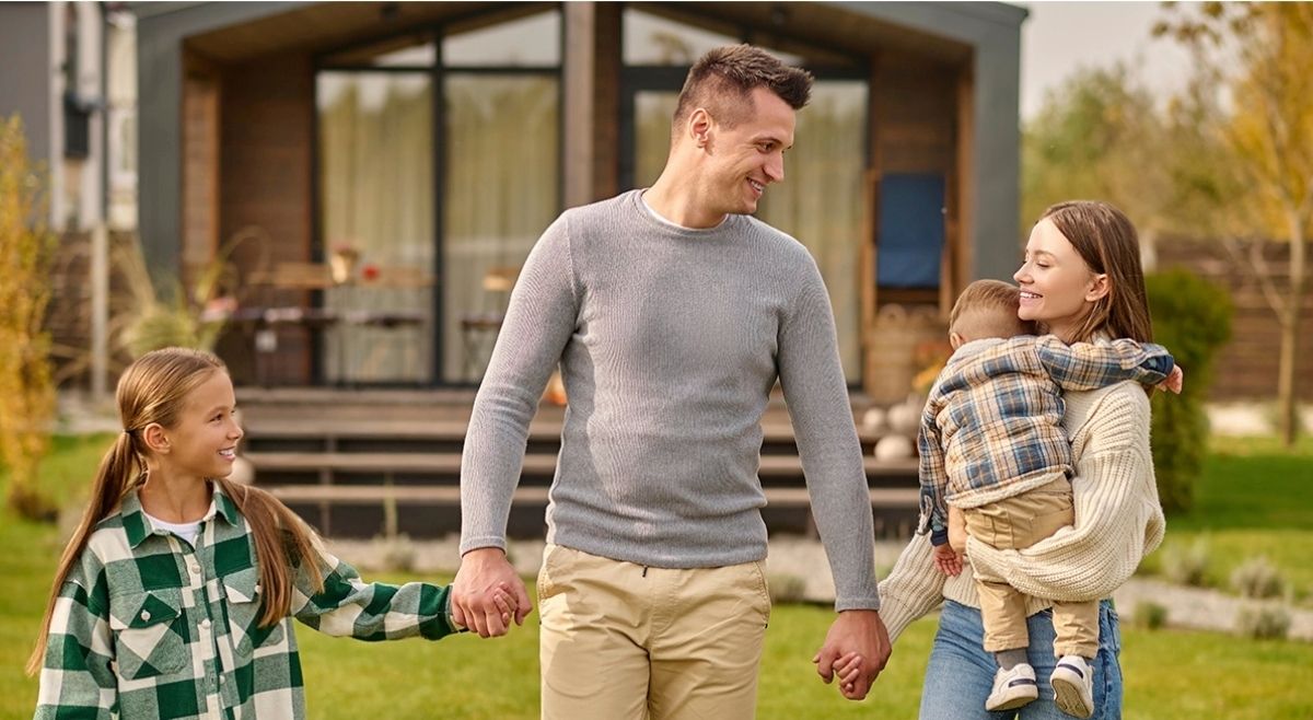 Familia joven frente a una casa unifamiliar en Orlando, representando la estabilidad del programa Section 8 y la renta garantizada para inversores extranjeros.