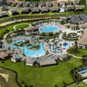 Vista aérea del área de amenidades de ChampionsGate con piscinas resort, palmeras y comunidad de vacation homes cerca de Orlando, Florida