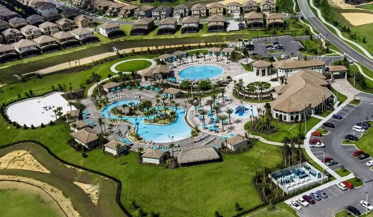 Vista aérea del área de amenidades de ChampionsGate con piscinas resort, palmeras y comunidad de vacation homes cerca de Orlando, Florida