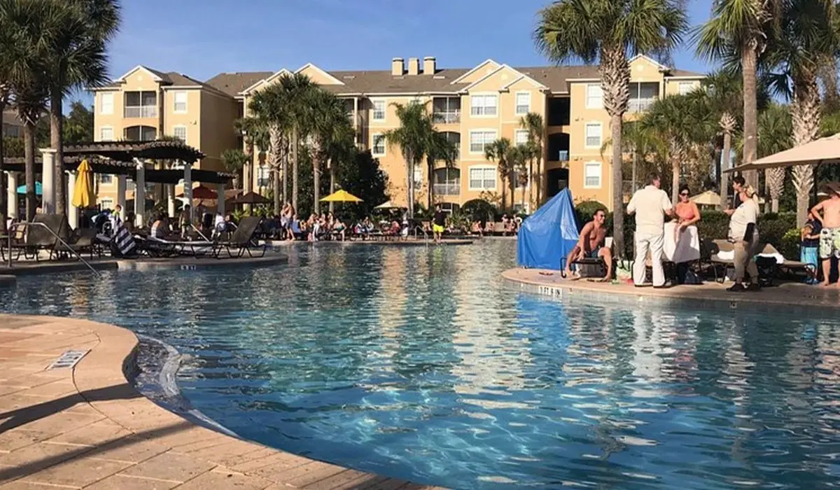 Piscina estilo laguna con huéspedes en Windsor Hills Resort, comunidad de vacation homes para inversión cerca de Kissimmee, Florida