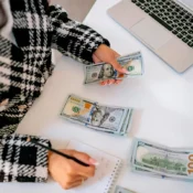 Mujer contando billetes de dólar para ahorrar el down payment de una propiedad en Florida.