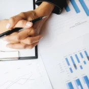 Manos revisando informes con gráficas para evaluar rentabilidad de propiedad en Orlando.
