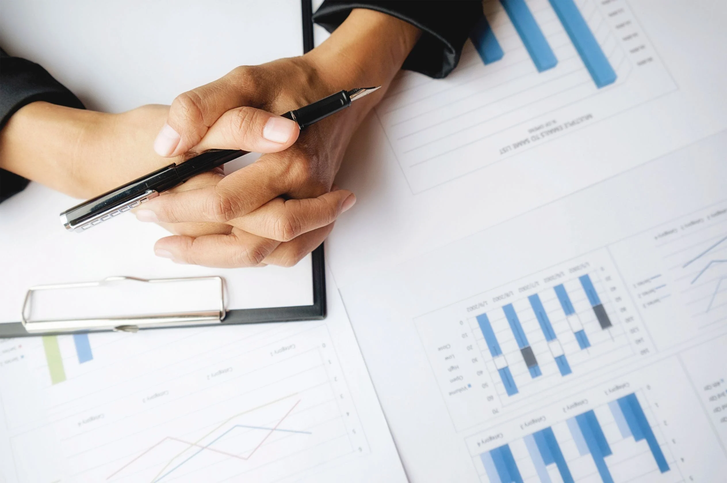 Manos revisando informes con gráficas para evaluar rentabilidad de propiedad en Orlando.