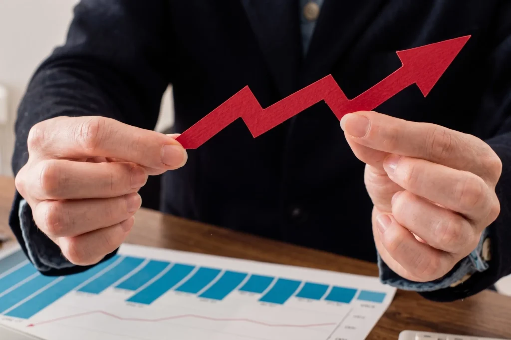 Hombre sosteniendo flecha roja ascendente sobre gráficas de inversión inmobiliaria en Orlando.