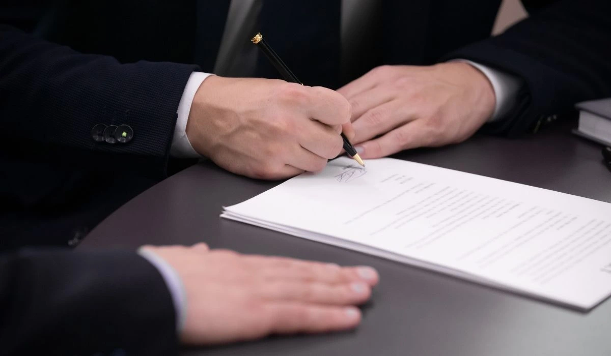 Persona firmando documento legal para constituir trust o LLC en Florida.