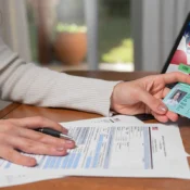 Persona sosteniendo green card frente a documentos para construir historial crediticio en EE.UU.