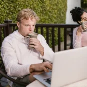 Pareja con laptops en terraza revisando rentabilidad de propiedad Airbnb Orlando