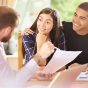 Mexican couple smiling during mortgage approval consultation for a Florida home.