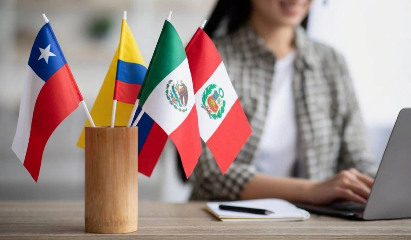 Mujer buscando los requisitos para comprar casa en Florida junto a banderas de Chile, Colombia, México y Perú.