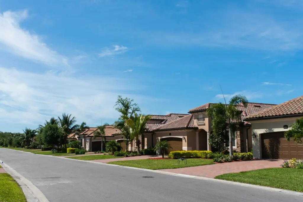 Fila de casas residenciales con palmeras en un vecindario de Florida bajo un cielo despejado.