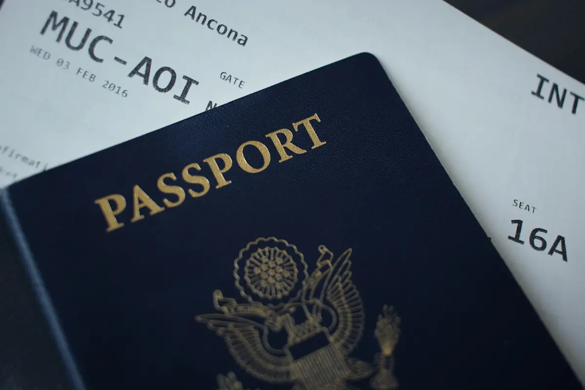 Pasaporte sobre un pase de abordar que representa la identificación necesaria para que extranjeros soliciten el ITIN e inviertan en Florida.
